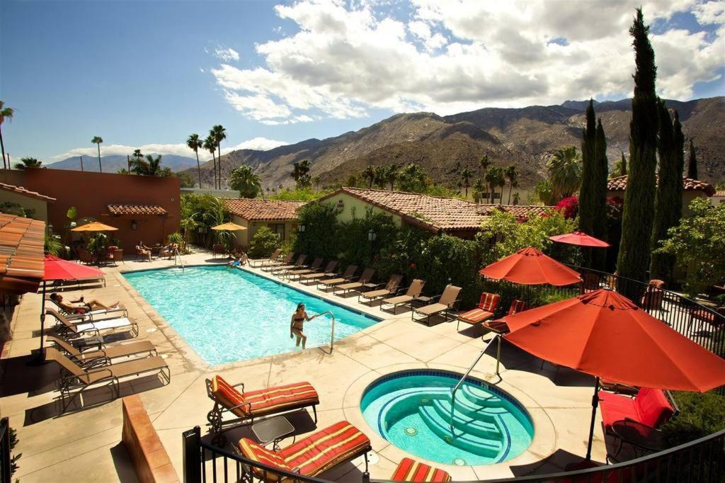 棕榈泉阿博尔斯大酒店的度假村内带椅子和遮阳伞的游泳池