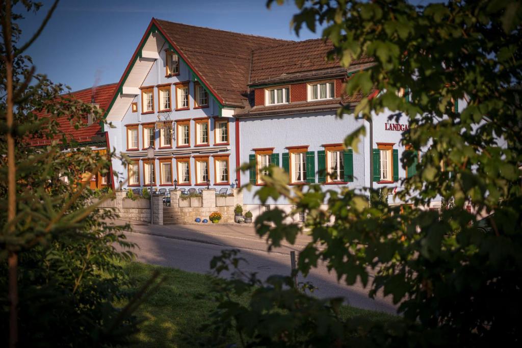 阿彭策尔Hotel Landgasthaus Neues Bild, Eggerstanden的一座带绿色百叶窗的大型白色建筑