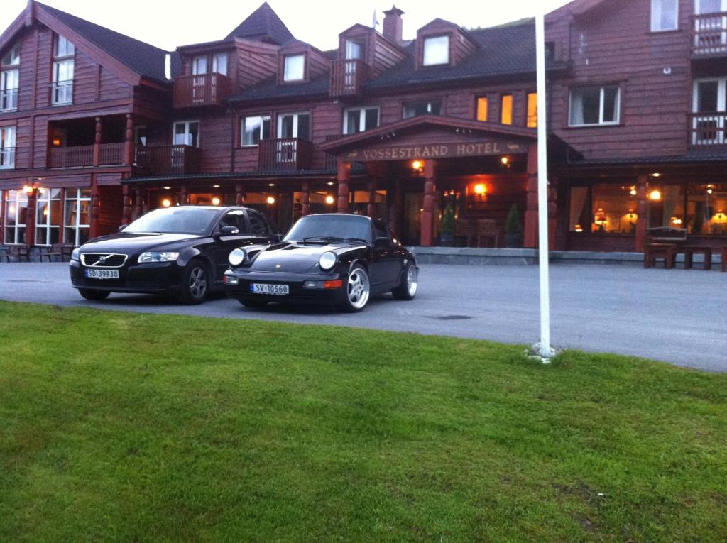 米尔克河谷沃思特朗德酒店和公寓的两辆汽车停在大楼前的停车场