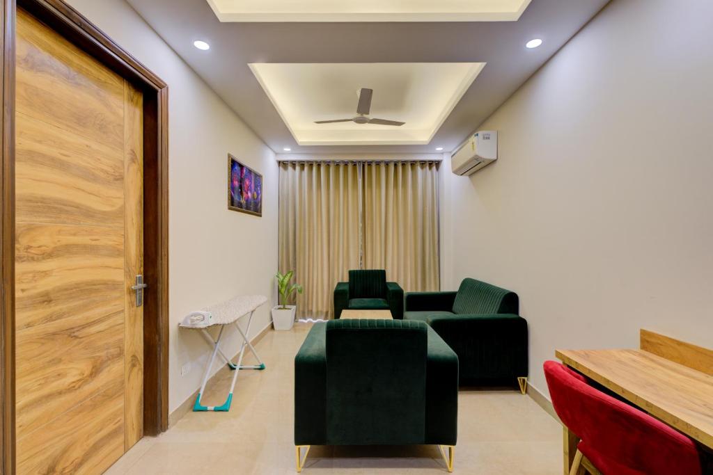 古尔冈1 BHK Serviced Apartments Near Millennium City Centre Gurugram with Private Washing Machine的一间设有绿色椅子和门的等候室