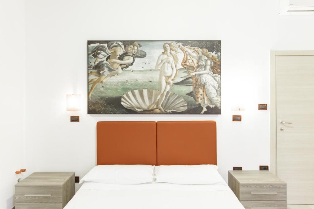 博洛尼亚IN FIERA 5 appartmento的卧室配有一张床,墙上挂有绘画作品