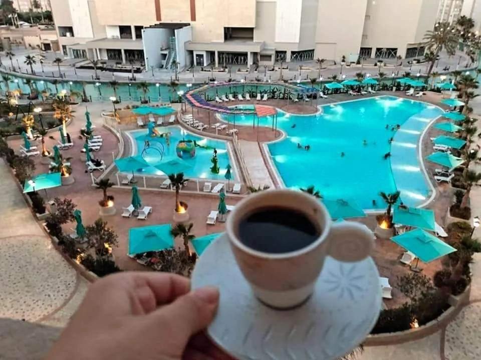 莫纳斯提尔Palm lake resort Folla Monastir的持杯咖啡的人