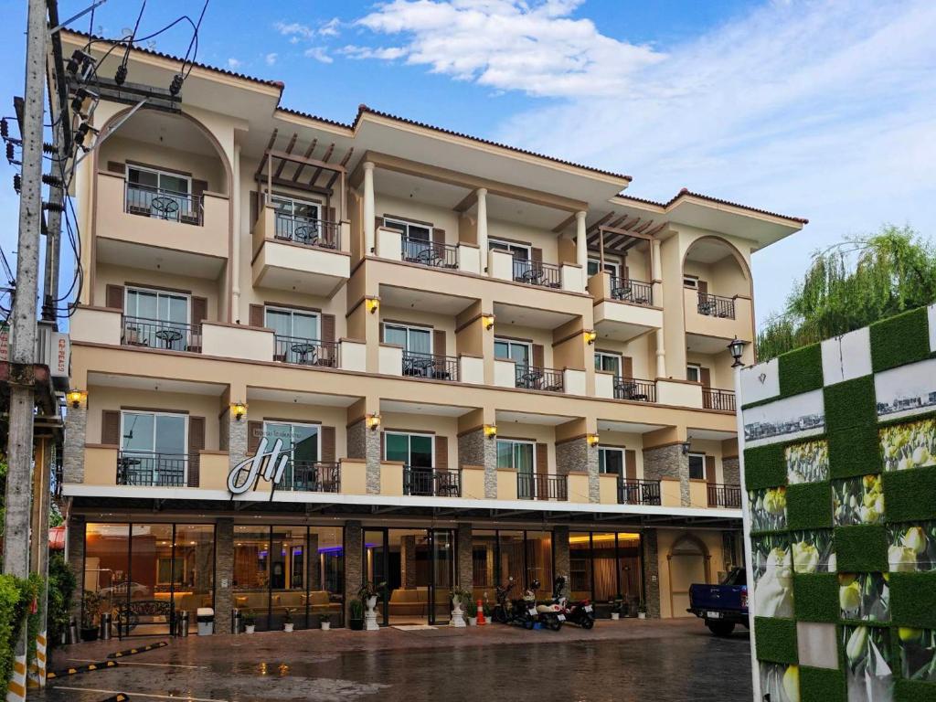 清莱Hi Chiangrai Hotel-SHA Extra Plus的街道上带阳台的大型建筑