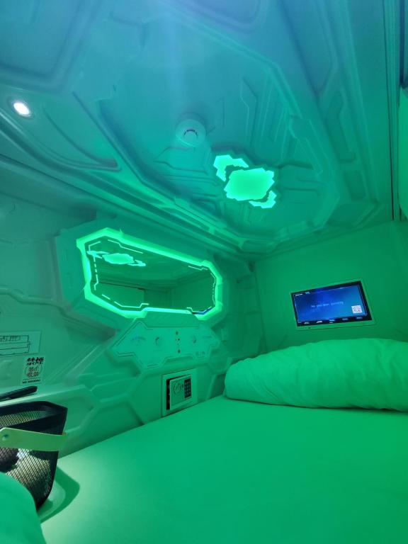 ŌsawaHotel Galaxy Pod的绿色的客房设有床和显示器