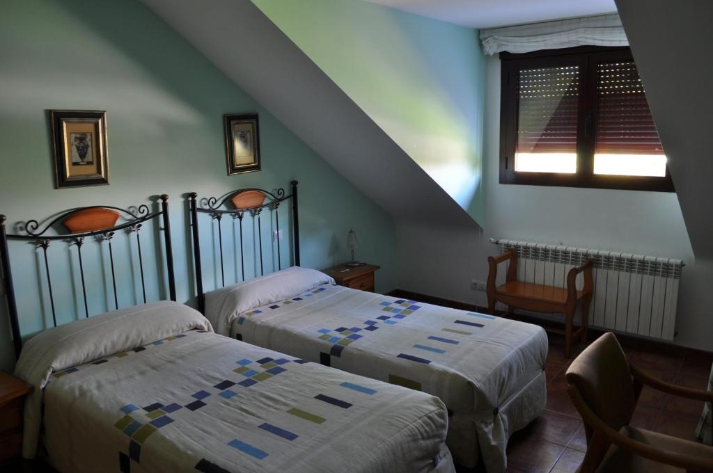 萨莫拉Hotel Puente de Piedra的一间带两张床的卧室和楼梯