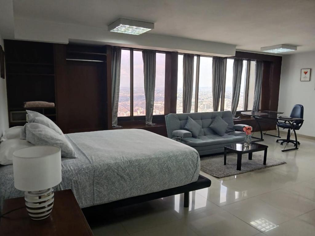 卡利TORRE DE CALI - Fabulosos Apartamentos pisos 6 al 39的一间带大床的卧室和一间客厅