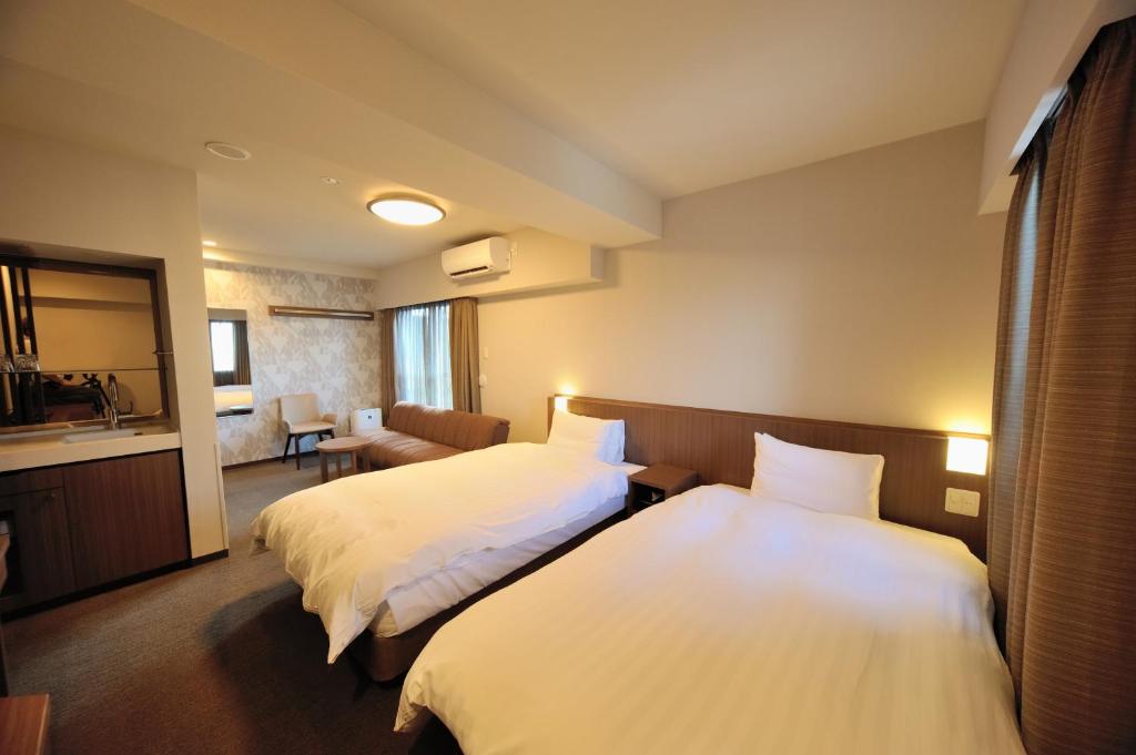 东京多美迎EXPRESS目黒青叶台酒店的酒店客房,设有两张床和一张沙发