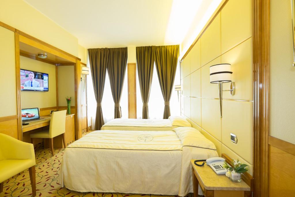 米兰特考酒店的配有一张床、一张书桌和一扇窗户的酒店客房