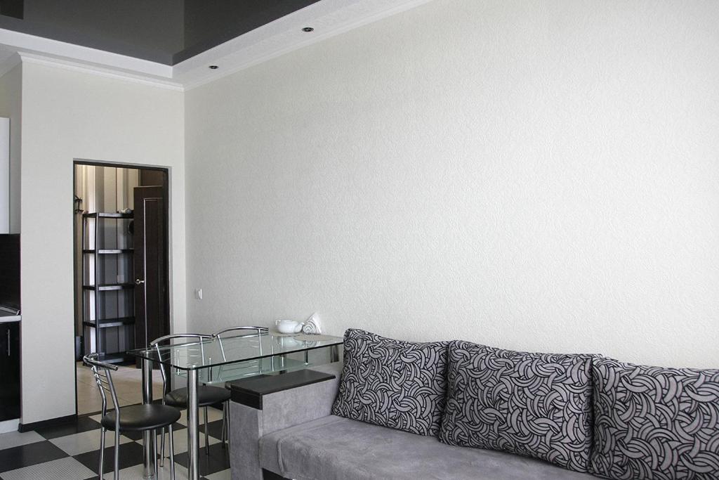 基辅Apartments on Rudanskogo的带沙发和玻璃桌的客厅