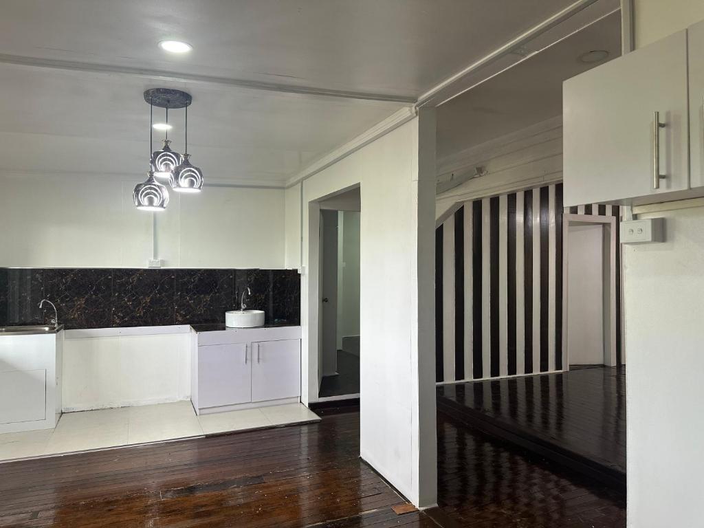 拉巴萨Large 3bdr Holiday Home Great Location Labasa的一间厨房,配有白色橱柜和楼梯