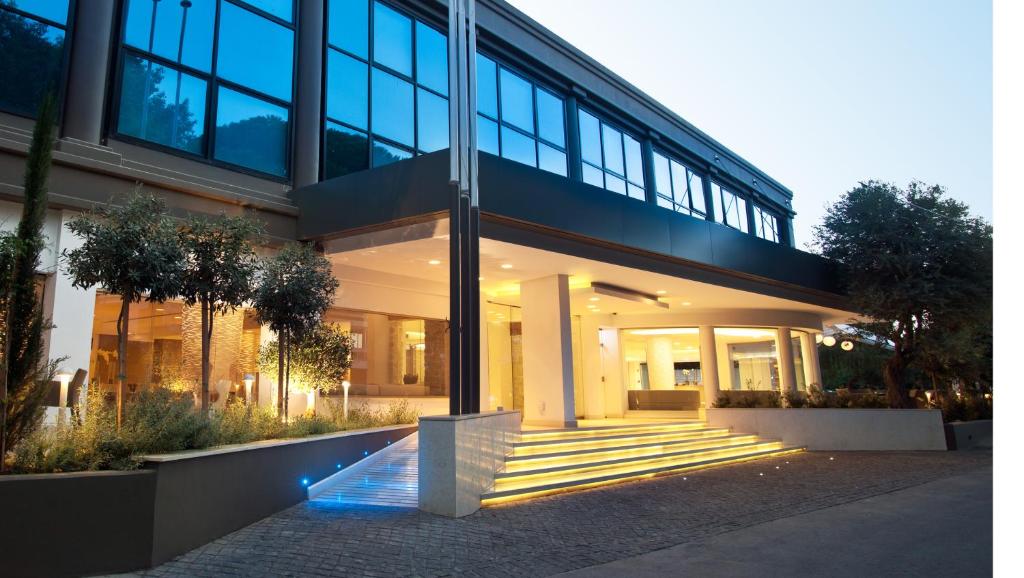 利马索尔阿拉思雅精品酒店的一座大型玻璃建筑,前面设有楼梯