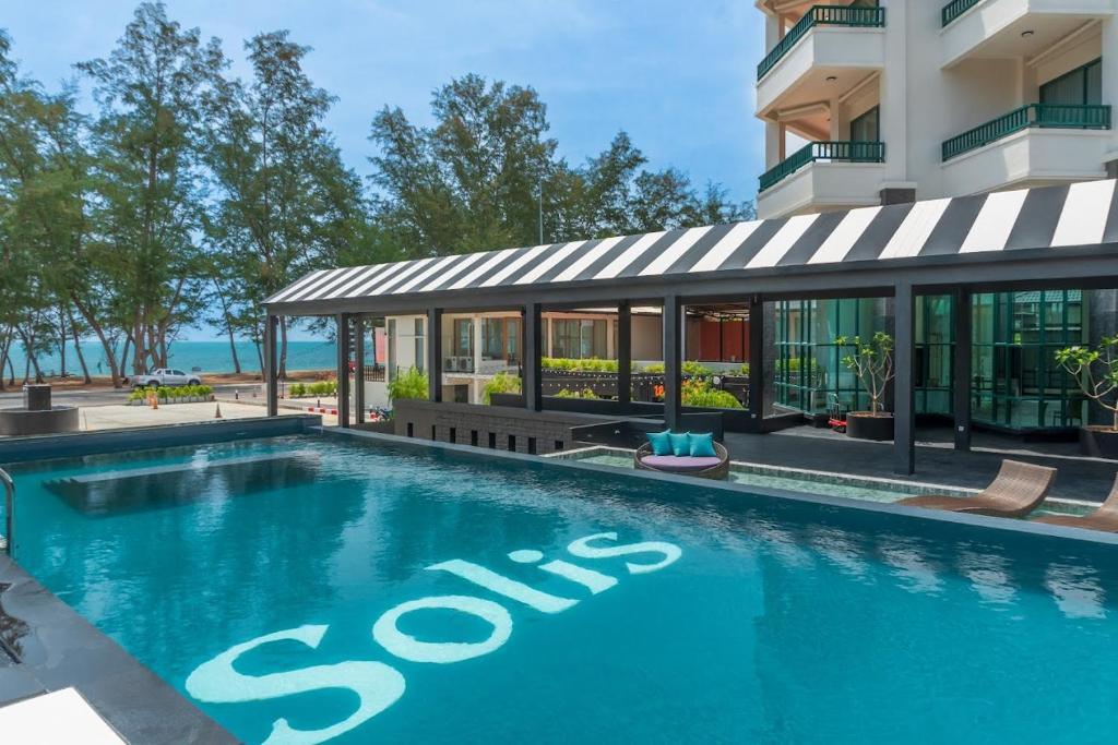 宋卡Solis Beach Hotel Rajamangala的大楼前有停车标志的游泳池