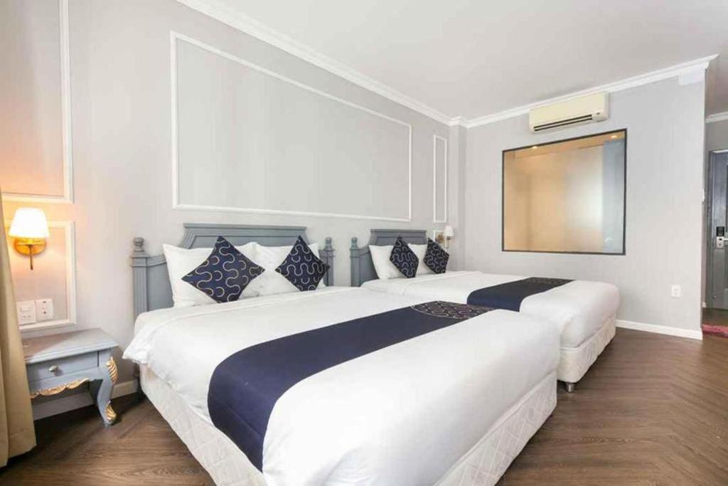 胡志明市Sabina Residence - Stellar Boutique Hotel的酒店客房内设有两张大床