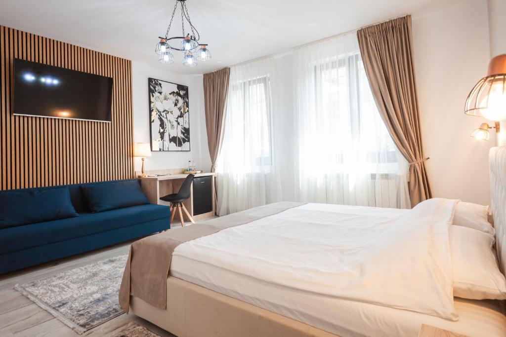 锡比乌ARINI WHITE HOUSE的一间卧室配有一张大床和一张蓝色的沙发
