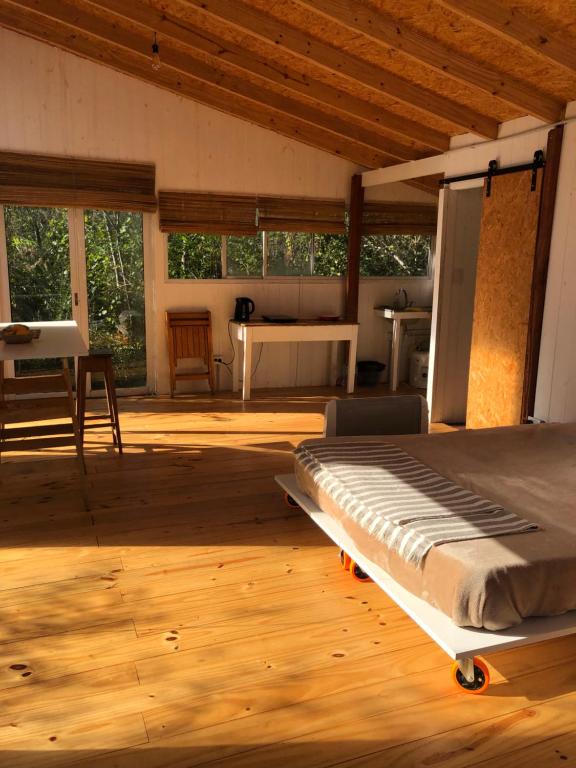 蒂格雷la casa en el rio的铺有木地板的客房内设有一间卧室和一张床。