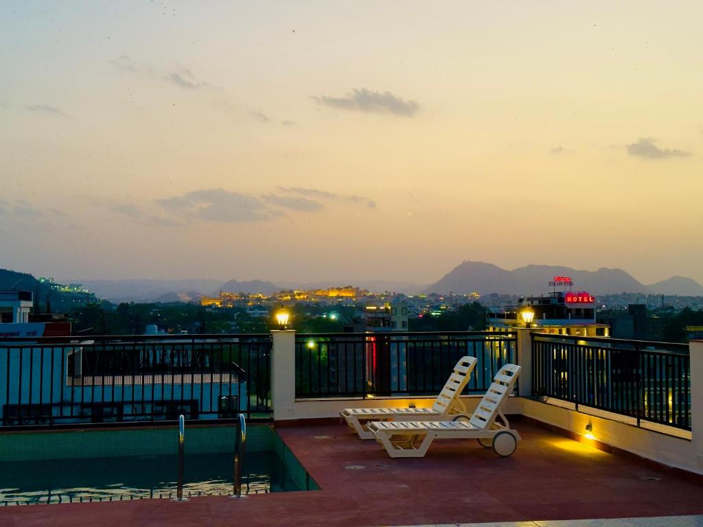 乌代浦Hotel De Glance Udaipur的市景阳台配有两把椅子