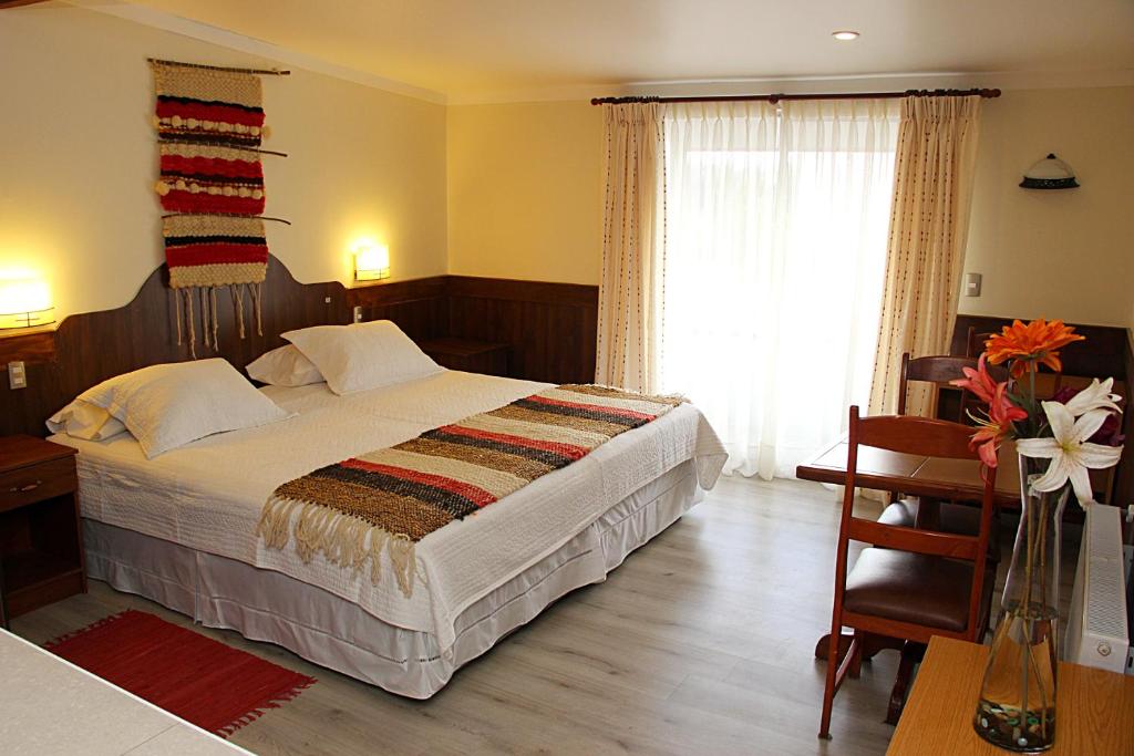 奥索尔诺鲁卡伊图埃酒店的一间卧室配有一张床、一张书桌和一个窗户。