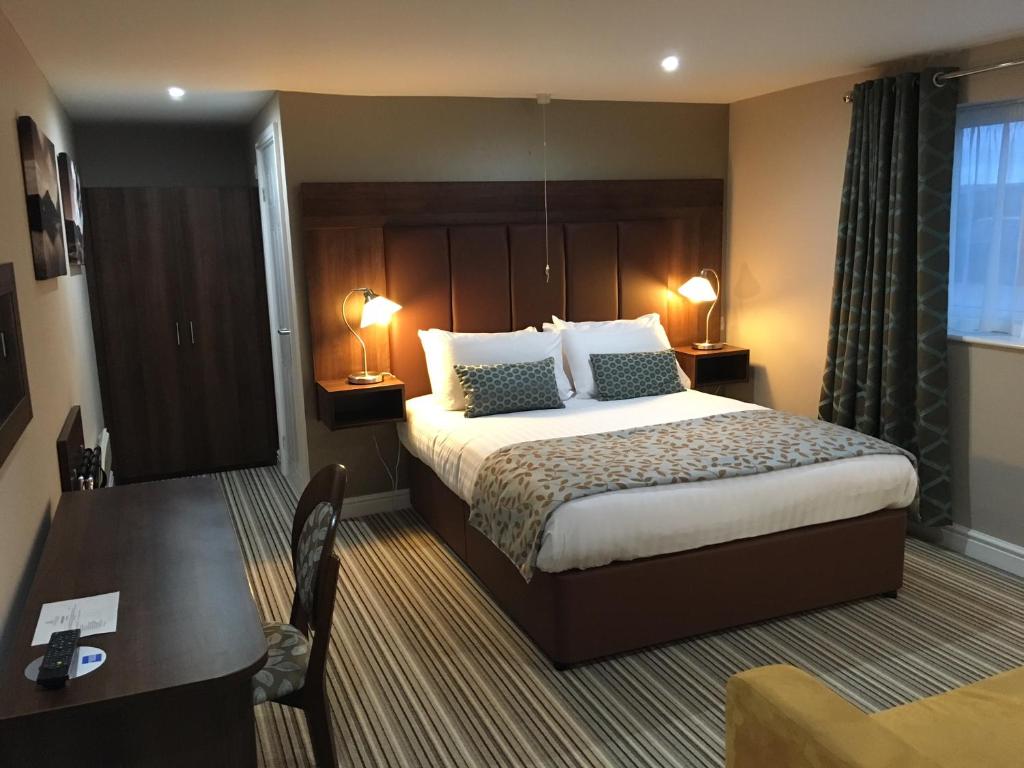 切斯特菲尔德双橡木酒店的酒店客房设有一张大床和一张书桌。