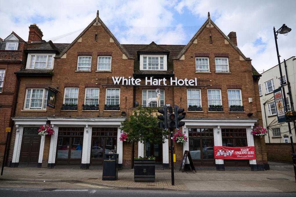 纽马基特White Hart, Newmarket by Marston's Inns的红砖建筑,带白色帽子酒店