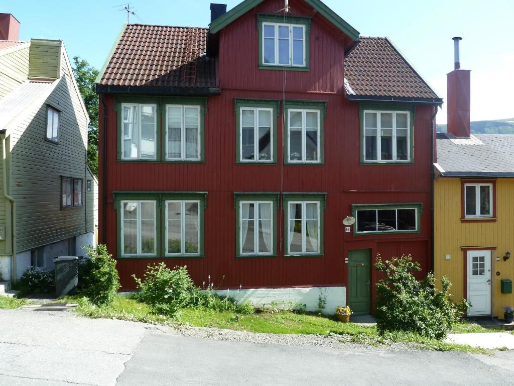 特罗姆瑟瑞德欧德豪斯特罗姆瑟公寓的街上有白色窗户的红色房子