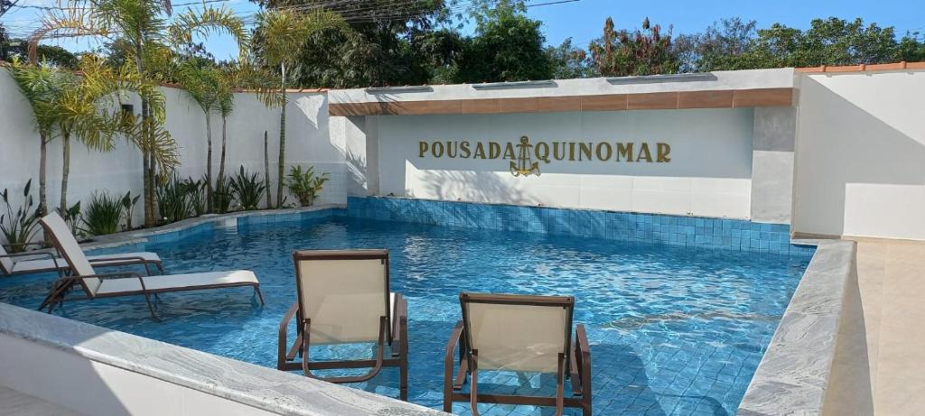 帕拉蒂Pousada Aquino Mar的度假村的两把椅子和一个游泳池