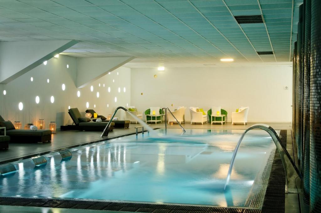 吉马良斯开房村体育温泉酒店的在酒店房间的一个大型游泳池