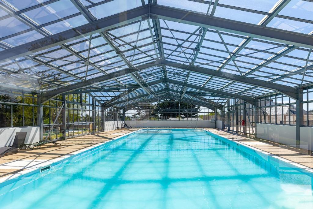 盖朗德Les Cottages de La Baule : Chalet de standing 7 personnes - Piscine的一个带玻璃天花板的大型室内游泳池