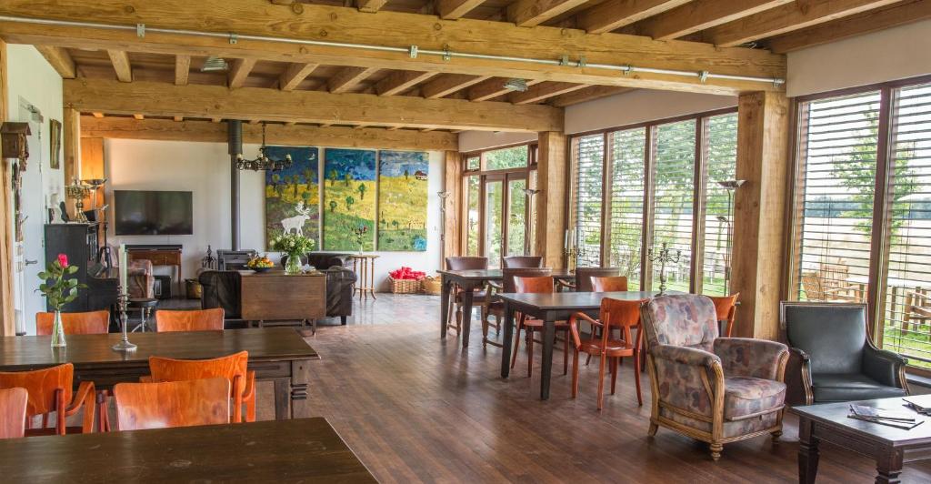 Oud-Gastel鲁金博夫住宿加早餐旅馆的用餐室设有桌椅和窗户。