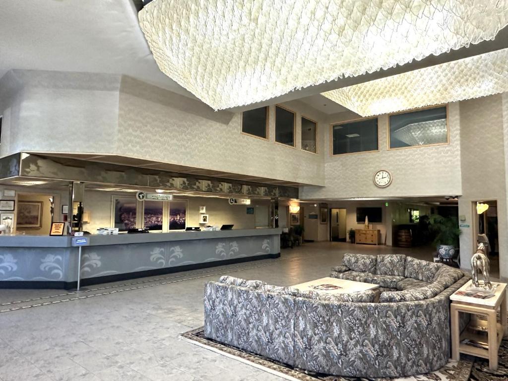 波特兰Sojourn Suites Portland Airport的带沙发的大型大堂和酒吧