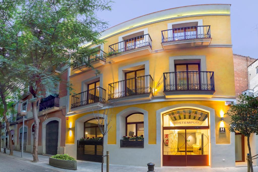 巴塞罗那圣家堂精品酒店的街道上带阳台的黄色建筑