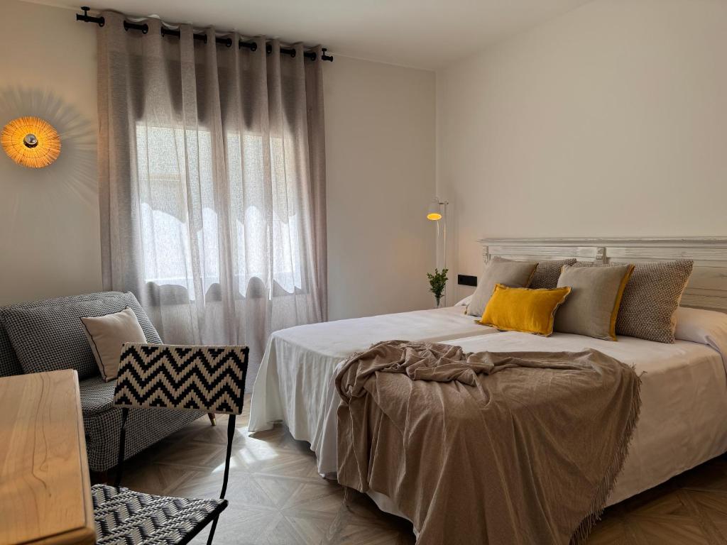 毕斯卡斯La Posada de Ruba的卧室配有床、椅子和窗户。