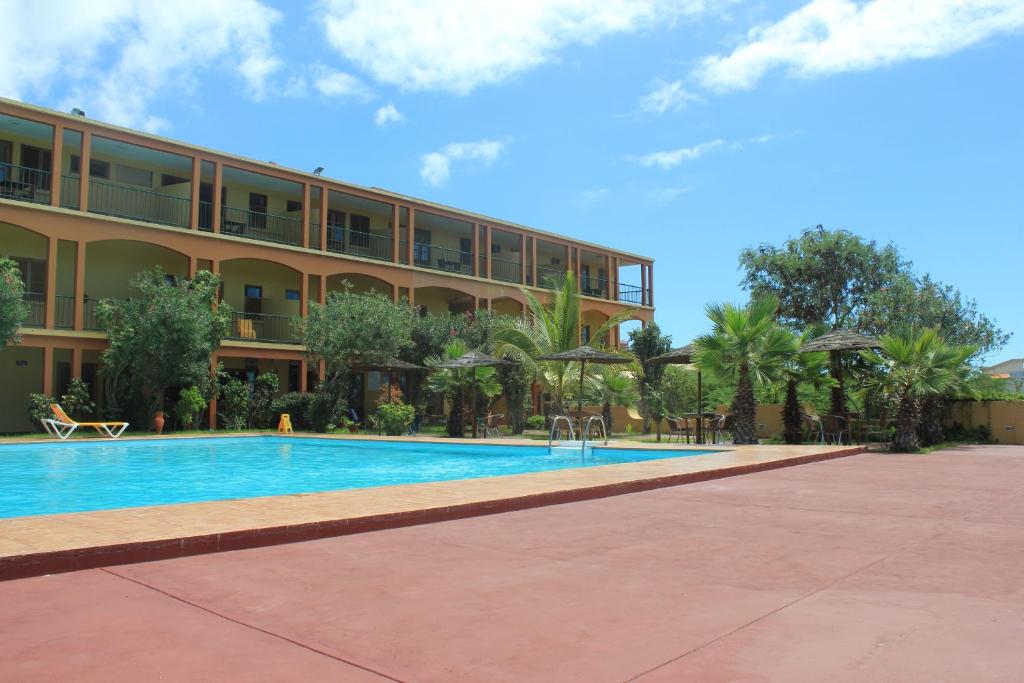 圣菲利佩Bamboo Xaguate Hotel的大楼前设有游泳池的酒店