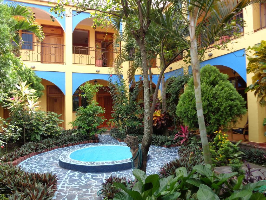 埃斯特利Hotel Los Arcos的一座庭院,位于一座拥有游泳池和树木的酒店