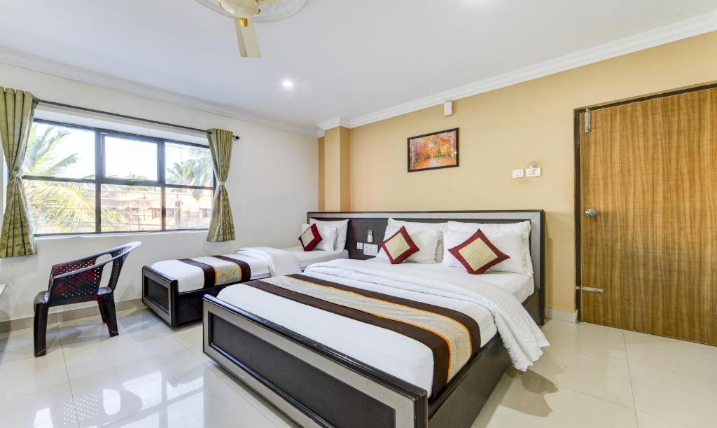 钦奈HOTEL SAlBALA INN - NEAR AIRPORT的一间卧室设有两张床和窗户。