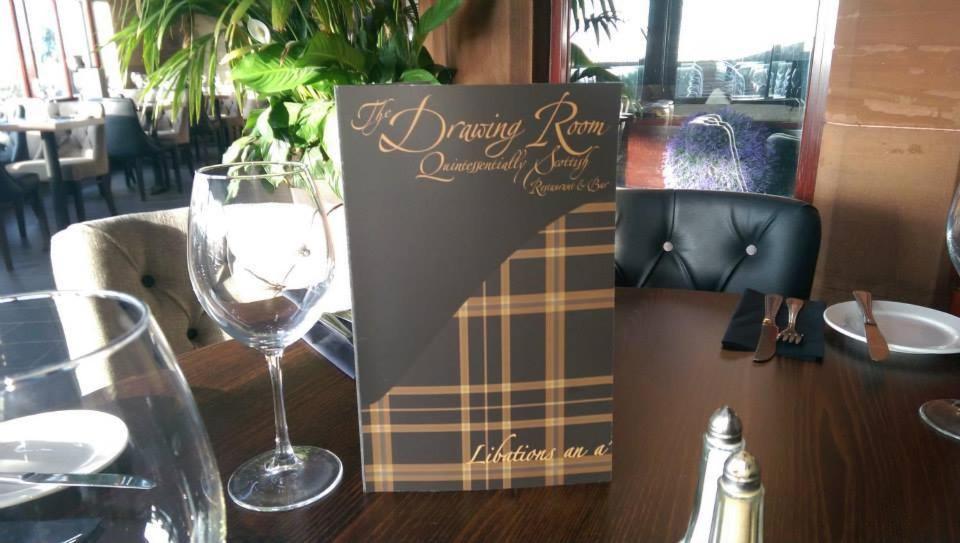 阿德罗森Lauriston Hotel的一张桌子上的标志,上面有酒杯