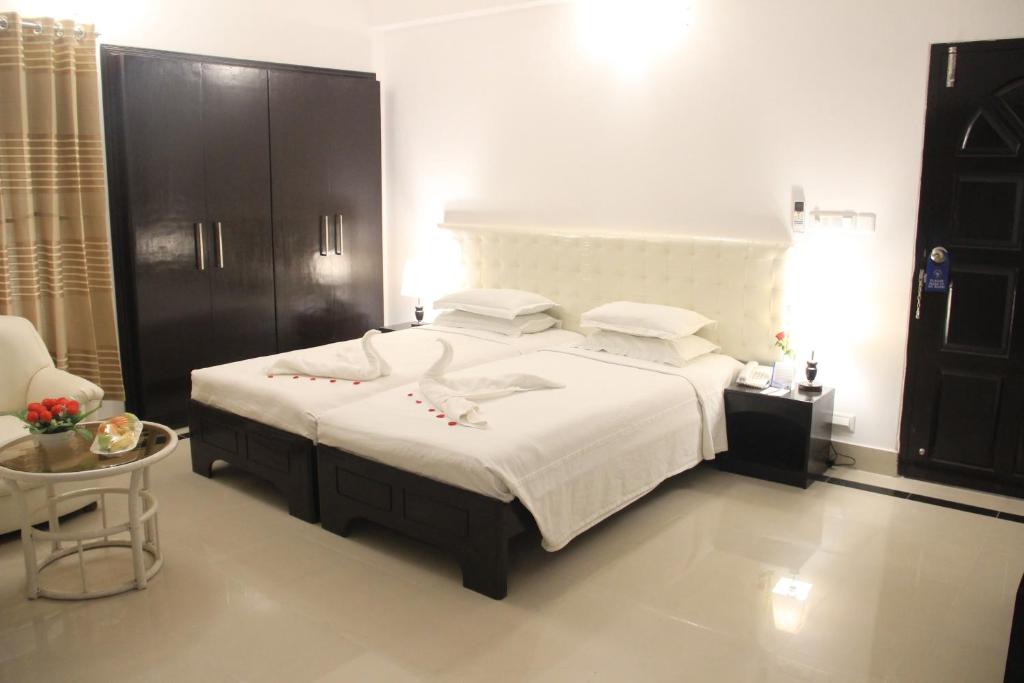 达卡贵族酒店的一间卧室配有一张大床和一张桌子