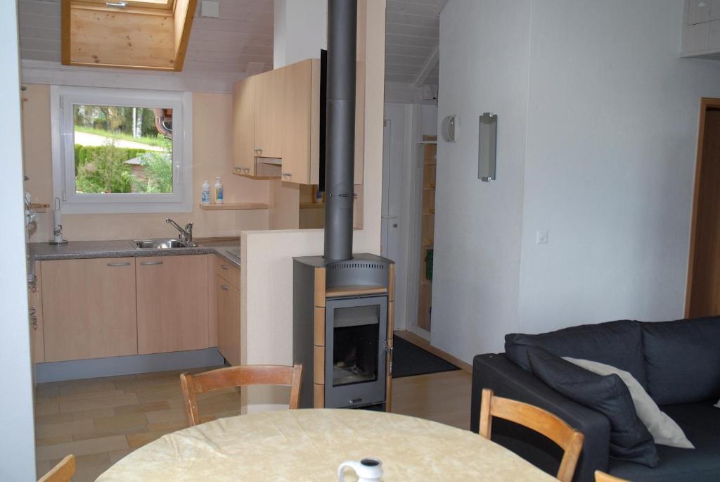 Les Geneveys-sur-CoffraneAppartment Aux Lilas的客厅设有壁炉和桌椅