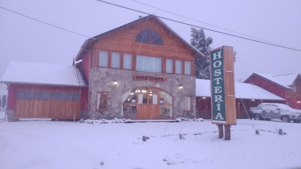 胡宁德洛斯安第斯Hosteria en Junin de los Andes的建筑物前雪中的标志