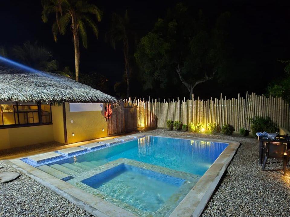 梅尔加Lujosa villa con piscina y cine privado的夜间在房子前面的游泳池