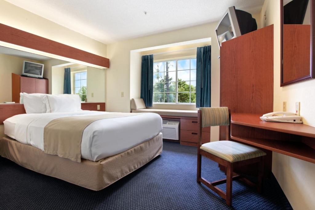 Rincon林孔套房酒店 的酒店客房设有一张大床和一张书桌。