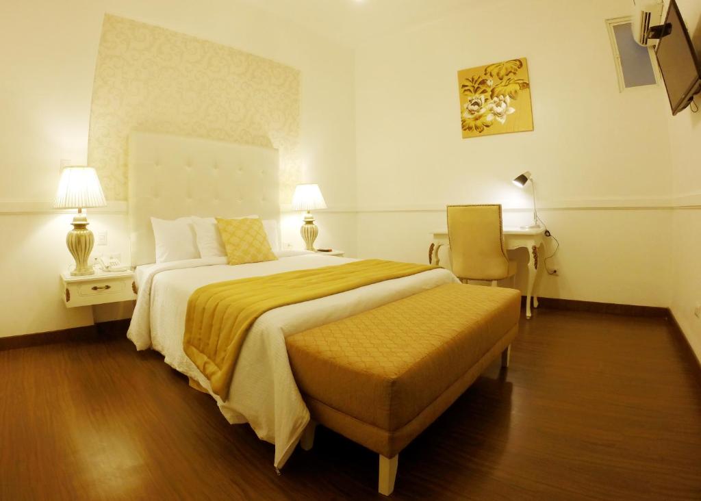 瓜亚基尔总统精品酒店的酒店客房设有一张大床和一张书桌。