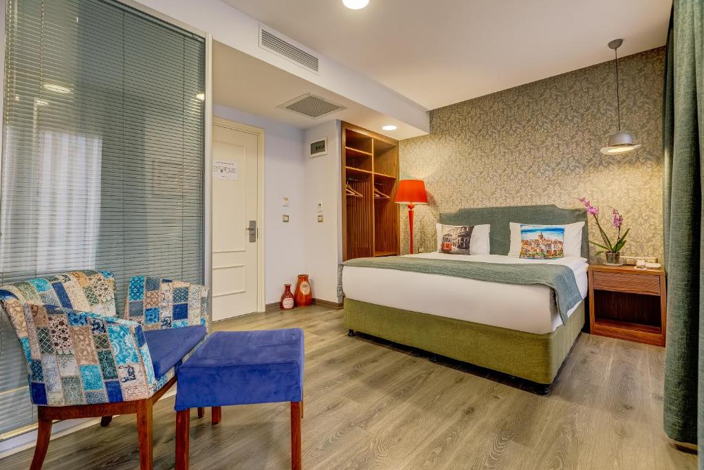 伊斯坦布尔塔克西姆逢时酒店 的卧室配有一张床和一张桌子及椅子