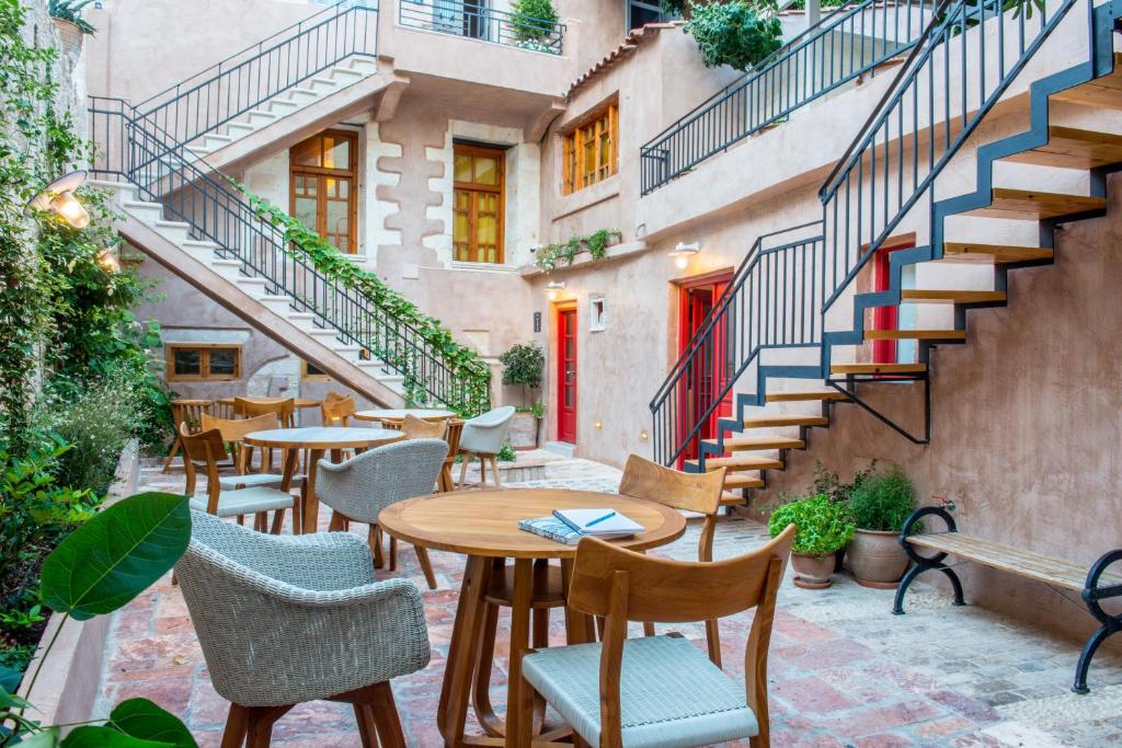 干尼亚奥夫酒店的庭院设有桌椅和楼梯。