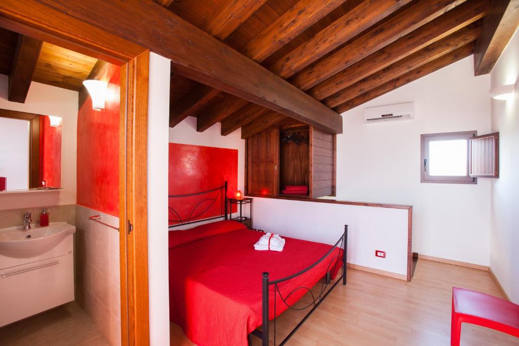 Collepasso佩拉德尔苏德住宿加早餐旅馆的一间在房间内配有红色床的卧室