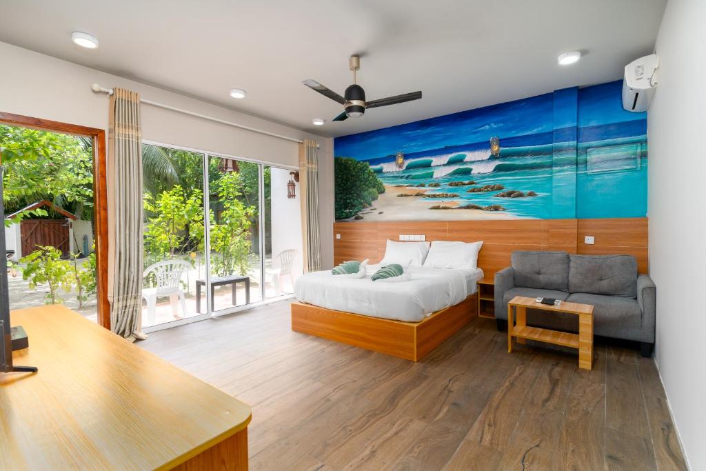 乌库拉斯Ukulhas Villa OceanView Hotel & Spa的一间卧室配有一张床、一张沙发和一张桌子