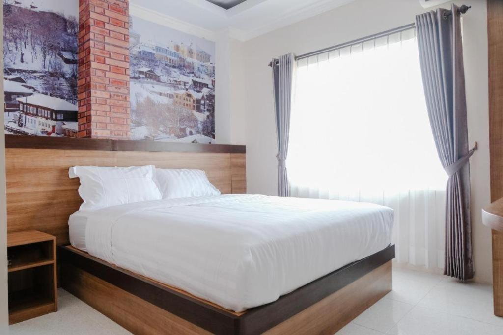 玛琅Noura Guest House Syariah的一间卧室设有一张大床和一个窗户。