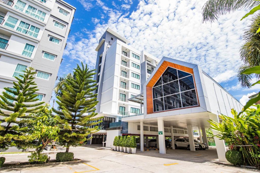 罗勇Phavina Hotel Rayong SHA Extra Plus的前面有树木的白色大建筑