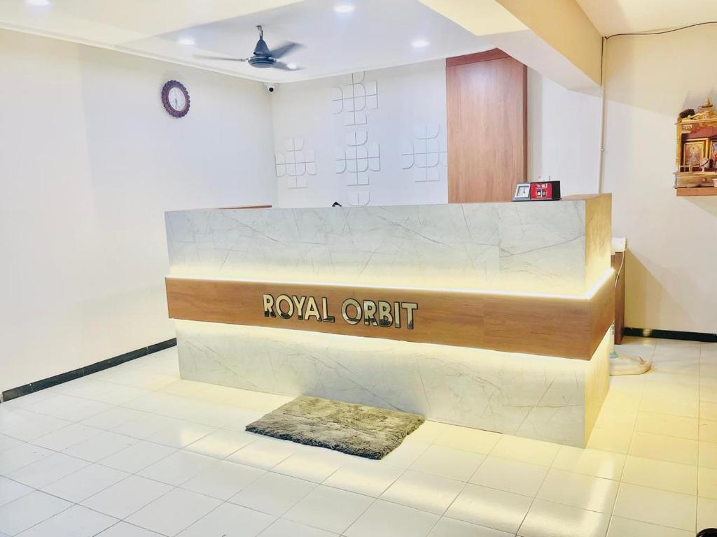 拉杰果德Hotel Royal Orbit的大厅,大理石柜台上设有皇家审计标志