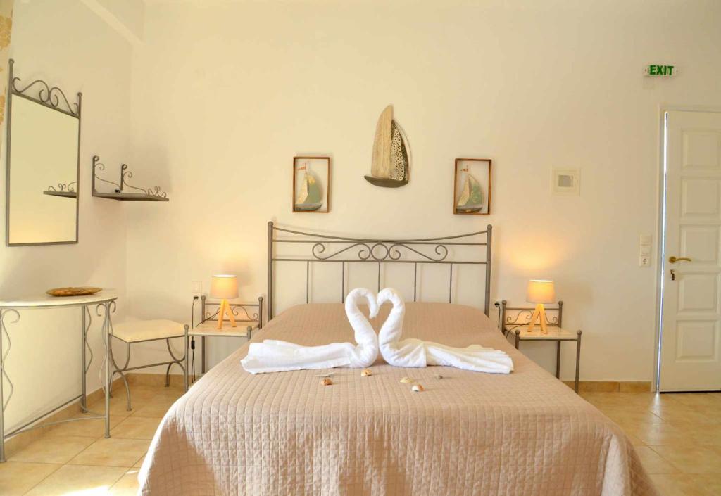 Agia Kiriaki BeachAperanto galazio的一间卧室配有带2条白色毛巾的床