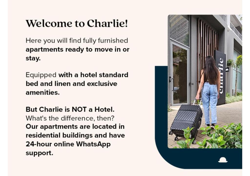圣保罗Charlie Jockey Pinheiros的一位女士提着行李箱走在人行道上